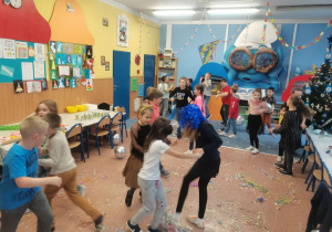 Grupa dzieci tańczy na środku klasy.