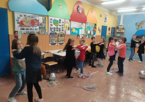 Grupa dzieci tańczy z balonikami.