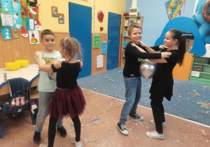 Grupa dzieci tańczy z balonikami.