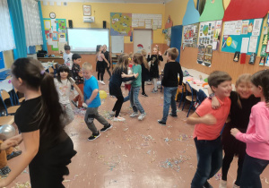 Dzieci tańczą na środku klasy.
