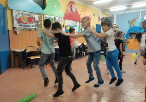 Dzieci tańczą na środku klasy tworząc węża.