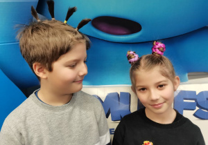 Dwoje dzieci prezentuje swoje fryzury.