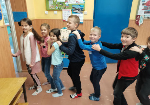 Dzieci tańczą tworząc węża do muzyki karnawałowej.