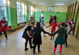 Dzieci z klasy III b tańczą na sali gimnastycznej.