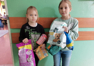 Dwie dziewczynki prezentują przyniesione przez siebie dary.