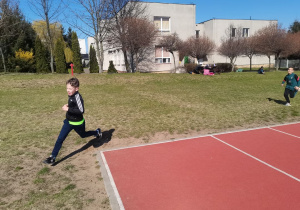 Chłopiec wbiega pierwszy na metę wyścigu.