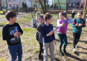 Grupa dzieci pokazuje odnalezione czekoladowe zające.