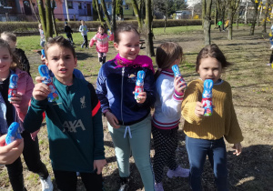 Grupa dzieci pokazuje odnalezione czekoladowe zające.