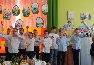 Antek i Mateusz śpiewają piosenkę do mikrofonu.