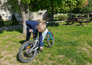 Chłopiec prezentuje swój rower.