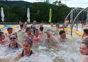 Dzieci bawią się w jacuzzi podziwiając górskie szczyty.