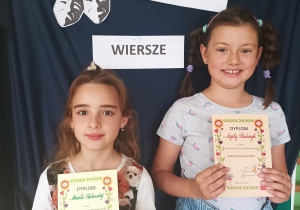 Uczniowie klasy II A trzymają dyplomy za udział w szkolnym konkursie recytatorskim "Bajkoludki lubią wiersze"