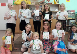 Dziewczęta prezentują dyplomy za konkurs recytatorski.