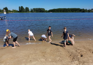 Dzieci bawią się w piasku i w wodzie.