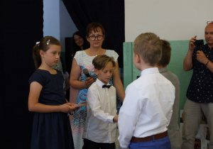 Dzieci wręczają koledze Paszporty Czwartoklasistów.