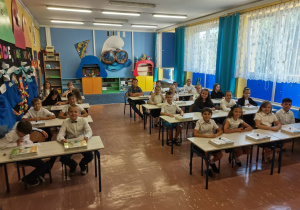 Uczniowie siedzą w swojej klasie.