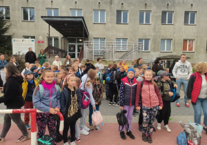 Dzieci stoją przed szkołą.