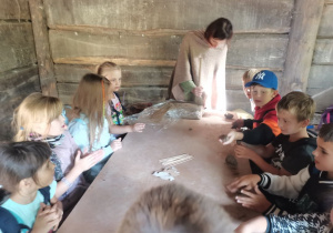 Dzieci uczestniczą w warsztatach tkackich i lepienia z gliny.