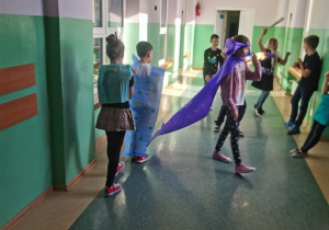 Uczniowie prezentują na korytarzu szkolnym "wykropkowane" stroje.
