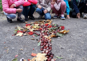 Uczniowie z grupy 2 prezentują drzewo wykonane żołędzi, kasztanów, jarzębiny i liści.
