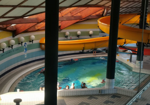 Uczniowie pływają w małym basenie.
