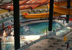 Uczniowie pływają w małym basenie.