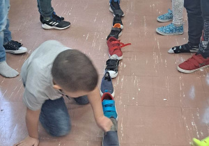Dzieci wróżą z butów ustawianych wzdłuż klasy.