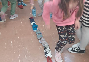 Dzieci wróżą z butów ustawianych wzdłuż klasy.