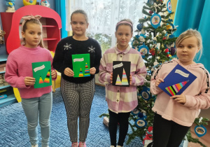 Dziewczynki prezentują własnoręcznie wykonane kartki świąteczne.