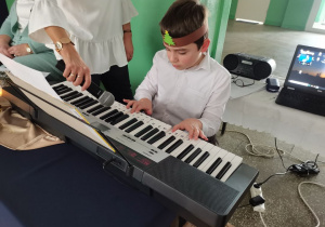 Chłopiec gra na keyboardzie.