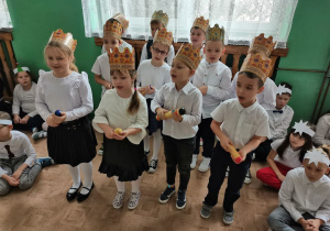 Dzieci śpiewają kolędę i grają na instrumentach perkusyjnych.