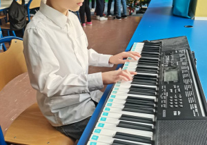 Chłopiec gra kolędę na keyboardzie.