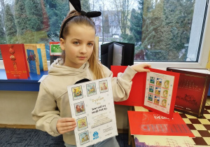 Dziewczynka prezentuje nagrody otrzymane w konkursie.