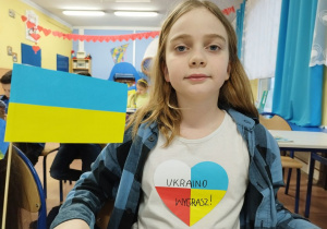 Chłopiec z ukraińską chorągiewką i napisem na koszulce: Ukraino, wygrasz!