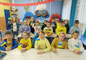 Uczniowie klasy III B z chorągiewkami oraz strojami w barwach ukraińskich
