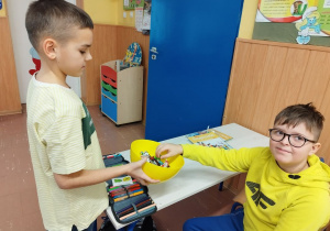 Chłopiec częstuje dzieci słodyczami przekazanymi od ukraińskiego kolegi.