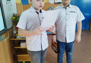 Dwaj członkowie samorządu szkolnego składają życzenia pracownicom Bajkolandii