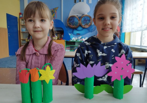 Dziewczynki prezentują wykonane papierowe kwiatki