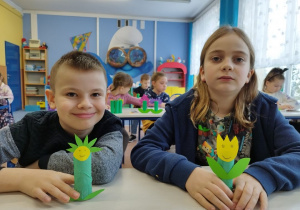 Uczniowie prezentują wykonane papierowe kwiatki