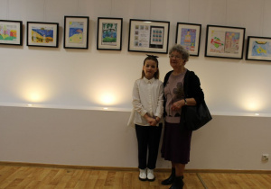 Marcelinka pozuje do zdjęcia z gośćmi wystawy