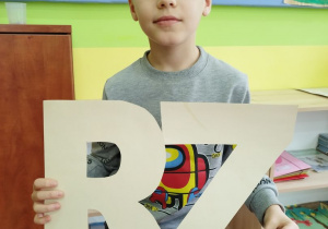Chłopiec trzyma dwuznak RZ