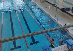 Uczniowie ćwiczą pływanie różnymi stylami.