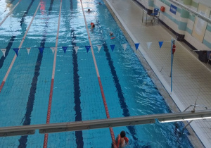 Uczniowie ćwiczą pływanie różnymi stylami.