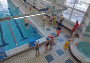 Uczniowie trenują skoki do basenu.