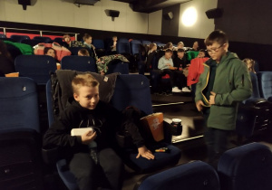 Uczniowie czekają na projekcję filmu w sali kinowej.
