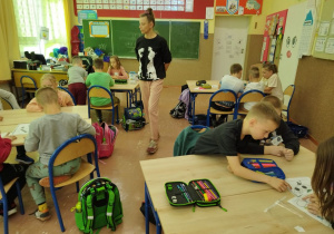 Wychowawczyni kontroluje pracę uczniów.