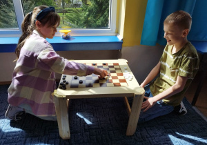 Dzieci uczestniczą w konkursie gry w warcaby.