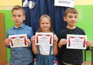 Uczniowie z klasy IC trzymają dyplomy uczestnictwa w konkursie "Bajkoludki lubią wiersze"