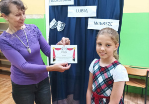 Uczennica z klasy IIIB otrzymuje dyplom uczestnictwa w konkursie "Bajkoludki lubią wiersze"