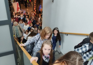 Uczniowie wchodzą po schodach na piętro teatru.